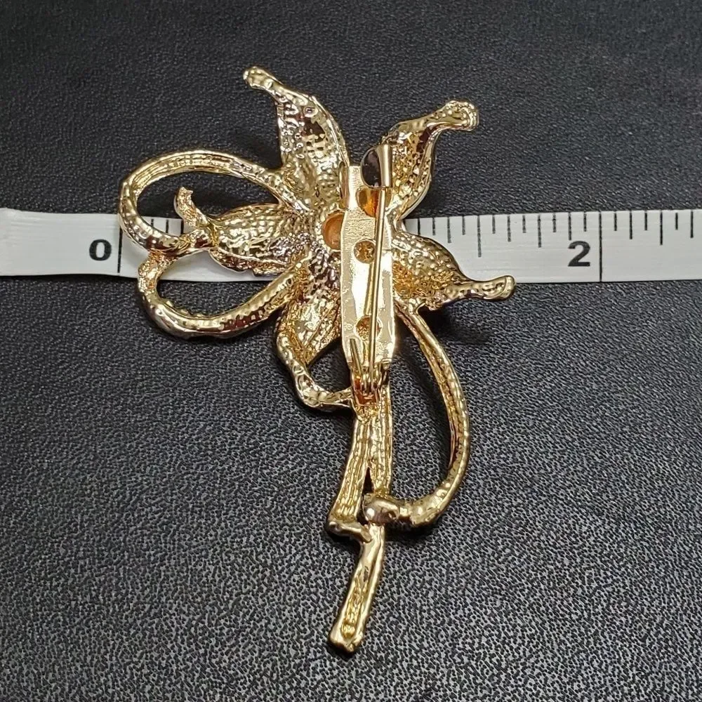 Gold tone blue and white flower brooch